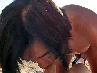 Egy meztelen ázsiai férfi mélytorkú szopást ad egy fehér férfinak egy mediterrán tengerparton