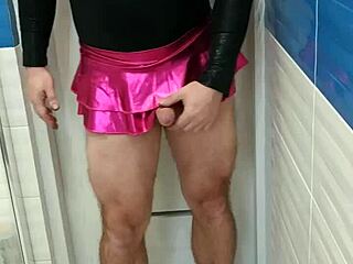 En smuk transkønnet kvinde viser frem sin sexede lyserøde trøje og skinnende nederdel