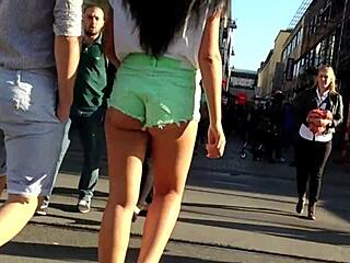 Attraktiv ung kvinna i shorts rusar längs vägen